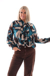 Doorknoop blouse strik roezels abstracte print petrol