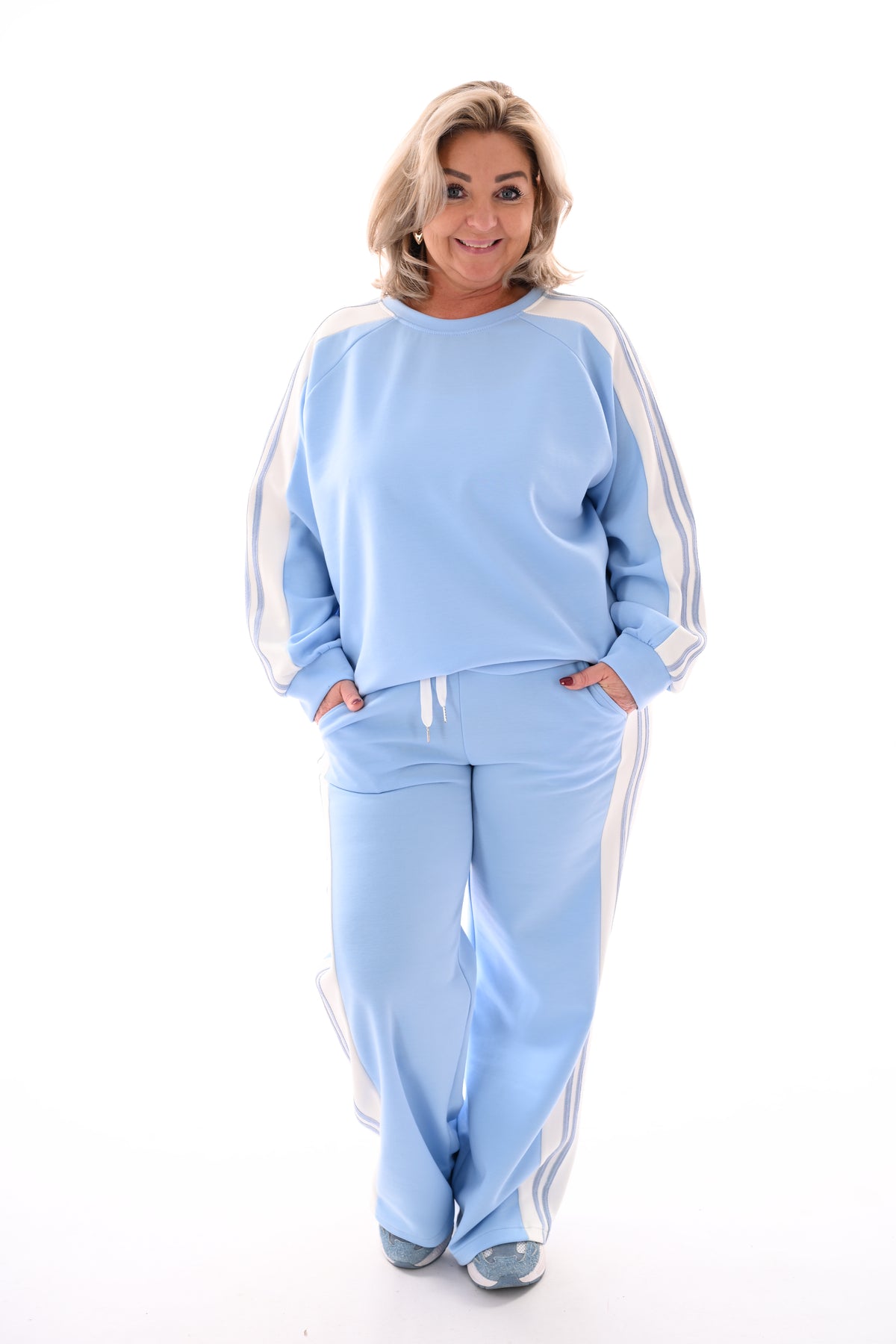 Tweedelig pak met bies lichtblauw