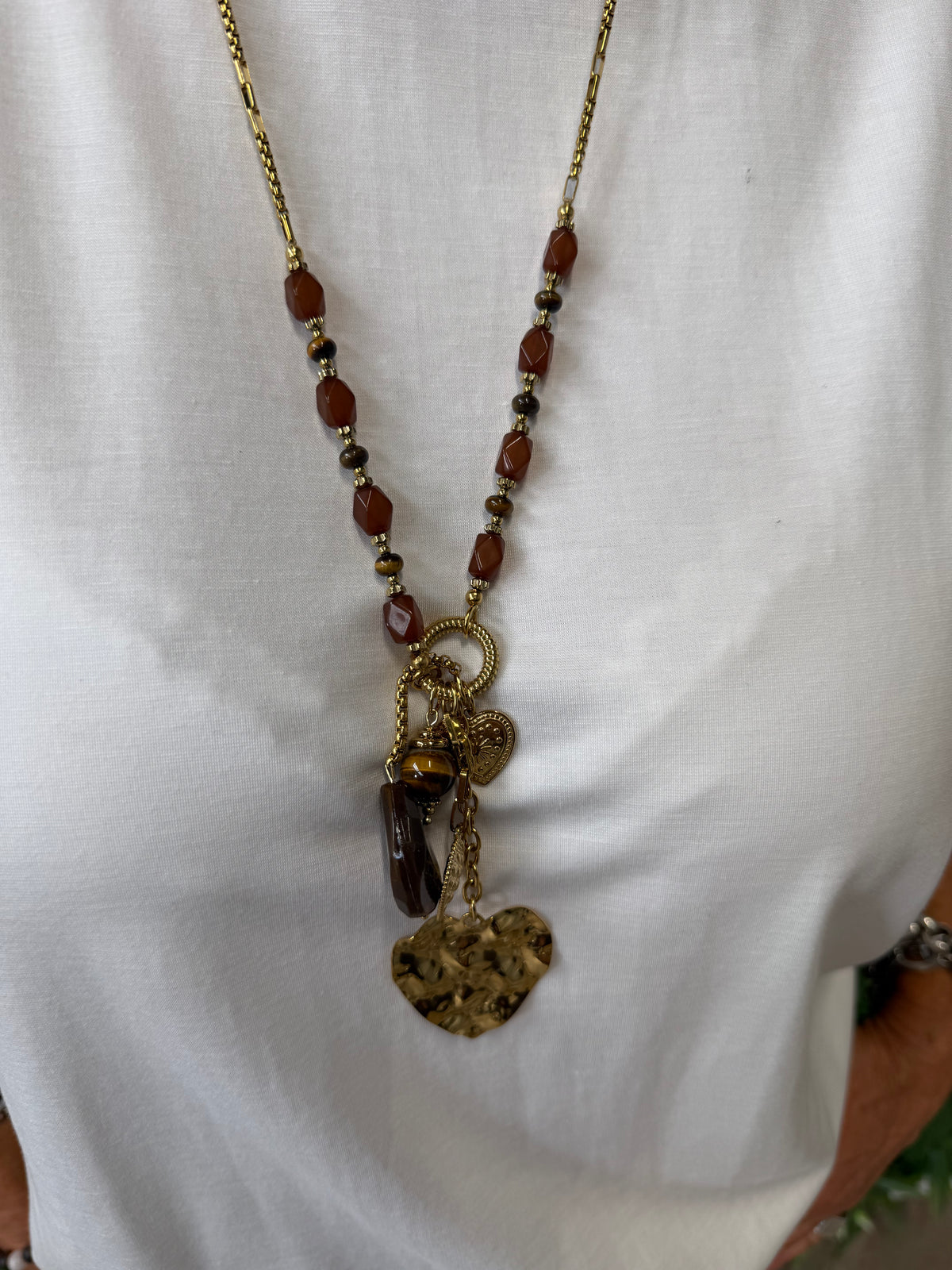 Lange stainless steel ketting met bruine kralen en hartje goud